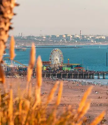 a beach with a ferris wheel and a pier at Wake Up to Waves – Beachside Bliss In Santa Monica in Los Angeles