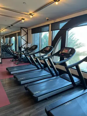 a row of treadmills in a gym with windows at SoCal Luxurious Apt Steps To The Beach & Pier in Los Angeles