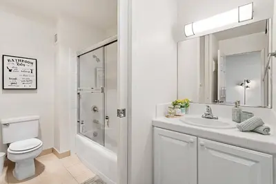 a white bathroom with a toilet and a sink at SoCal Luxurious Apt Steps To The Beach & Pier in Los Angeles