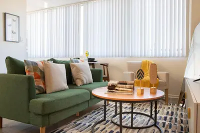 a living room with a green couch and a table at * Prime Location Studio Near Santa Monica Pier * in Los Angeles