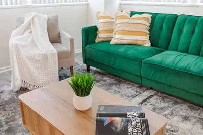 a green couch in a living room with a coffee table at Luxurious &Spacious 1Bed 1Bath Apt In Santa Monica in Los Angeles