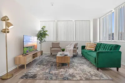 a living room with a green couch and a tv at Luxurious &Spacious 1Bed 1Bath Apt In Santa Monica in Los Angeles