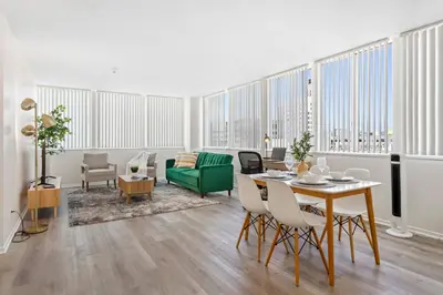 a living room with a table and a green couch at Luxurious &Spacious 1Bed 1Bath Apt In Santa Monica in Los Angeles
