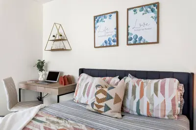 a bedroom with a bed and a desk with a laptop at Beachside Beauty Steps To The Beach & Restaurants in Los Angeles