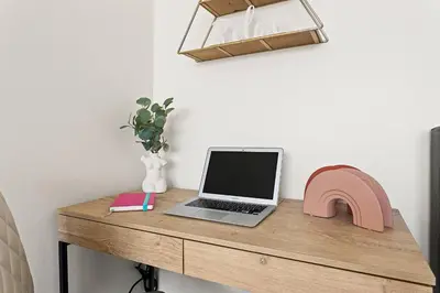 a desk with a laptop computer and a pink chair at Beachside Beauty Steps To The Beach & Restaurants in Los Angeles
