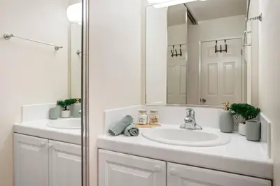 a white bathroom with two sinks and a mirror at Ocean Lover's Dream Studio In Santa Monica in Los Angeles