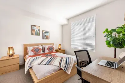 a bedroom with a bed and a desk with a laptop at 5 Star 1BR Apartment w/ Free Parking & Fast WiFi in Los Angeles