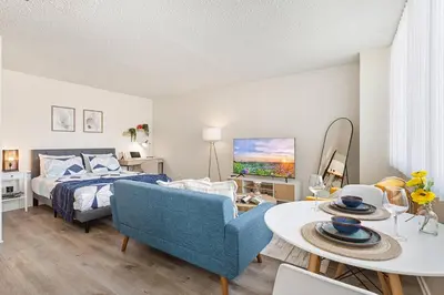 a bedroom with a bed and a table and a couch at 5-star West Hollywood Living | Modern & Central in Los Angeles