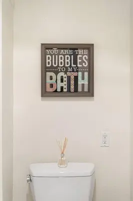 a picture on the wall above a toilet in a bathroom at 5-star West Hollywood Living | Modern & Central in Los Angeles