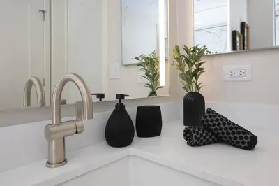 a kitchen counter with a sink with vases on it at 5-Star West Hollywood Living | Modern & Central in Los Angeles