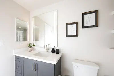a white bathroom with a sink and a mirror at 5-Star West Hollywood Living | Modern & Central in Los Angeles