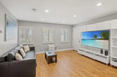 a living room with a couch and a large screen tv at Modern 1BR • Steps to Venice Beach in Los Angeles