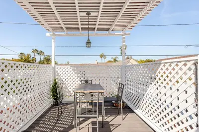 a white pergola on a deck with a table at Cozy 3-Bedroom Home in K-town Los Angeles in Los Angeles