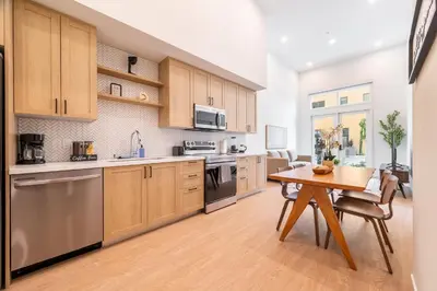 a kitchen with wooden cabinets and a wooden table with a wooden table at The Village Collection with Gym Pool and Spa in Montclair