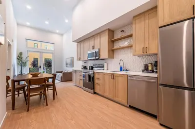 a kitchen with wooden cabinets and a table and a dining room at The Village Collection with Gym Pool and Spa in Montclair