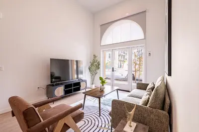 a living room with a couch and a tv at The Village Collection with Gym Pool and Spa in Montclair