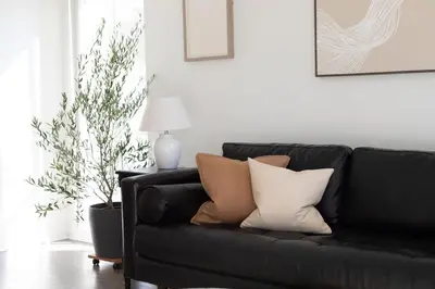 a black couch with pillows on it in a living room at King Bed, Gym, Hot Tub, Parking in Thousand Oaks