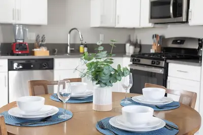 a kitchen with a table with plates and wine glasses at King Bed, Gym, Hot Tub, Parking in Thousand Oaks