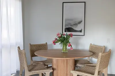 a dining room table with a vase of flowers on it at King Bed, Gym, Hot Tub, Parking in Thousand Oaks