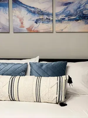 a white bed with four paintings on the wall at Pasadena Charming Vacation Home with Hot Jacuzzi in Pasadena