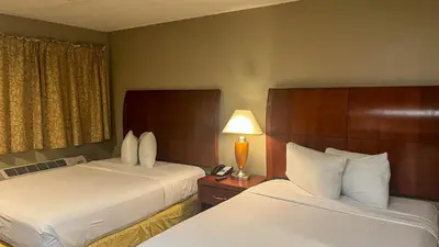 a hotel room with two beds and a lamp at Studio 6 Victorville Green Tree Bvld in Victorville