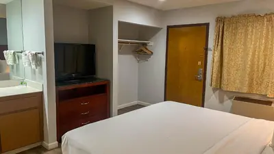 a bedroom with a bed and a television and a bathroom at Studio 6 Victorville Green Tree Bvld in Victorville