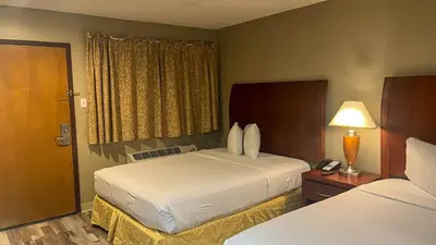 a hotel room with two beds and a telephone at Studio 6 Victorville Green Tree Bvld in Victorville