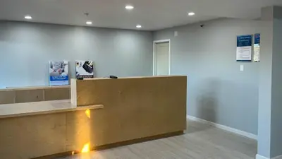 a lobby with a wooden counter and a wall at Studio 6 Victorville Green Tree Bvld in Victorville