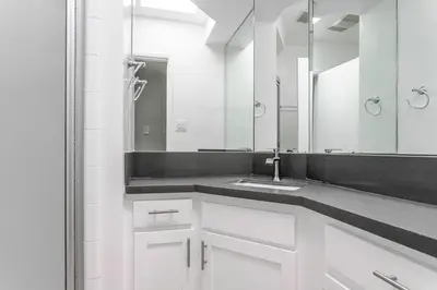 a white bathroom with a sink and a mirror at Blueground Westwood balcony nr UCLA LAX-1397 in Los Angeles