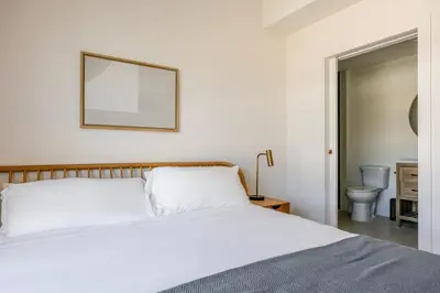a bedroom with a bed and a mirror and a toilet at Blueground East Hollywood balcony nr Echo Park LAX-1336 in Los Angeles