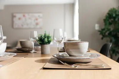 a wooden table with a bowl and plates and wine glasses at Excellent Town Home 2BR in WEHO Parking,Gym,Pool in Los Angeles