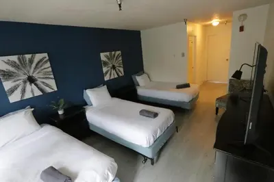 a hotel room with two beds and a television at 3 beds Apart in Beverly Hills in Los Angeles