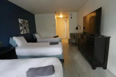 a hotel room with two beds and a flat screen tv at 3 beds Apart in Beverly Hills in Los Angeles