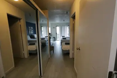 a room with two beds and a mirror at 3 beds Apart in Beverly Hills in Los Angeles