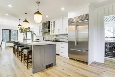 a kitchen with white cabinets and a stainless steel refrigerator at Walk to Lake Arrowhead Village! Home with Lake Views in Lake Arrowhead