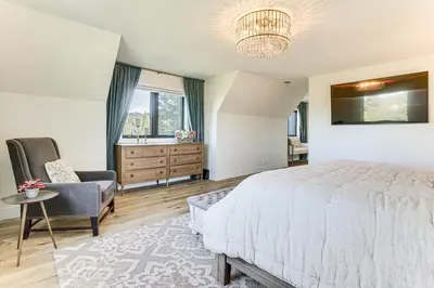 a bedroom with a bed and a chair and a window at Walk to Lake Arrowhead Village! Home with Lake Views in Lake Arrowhead