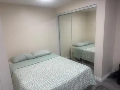 a small bedroom with a bed and a mirror at Peaceful Cottage in Vermont Knolls in Los Angeles
