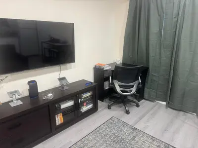 a room with a desk with a chair and a television at Peaceful Cottage in Vermont Knolls in Los Angeles