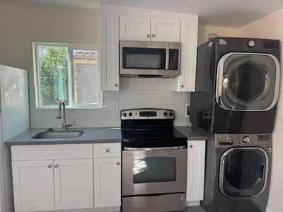 a kitchen with a sink and a stove and microwave at Peaceful Cottage in Vermont Knolls in Los Angeles