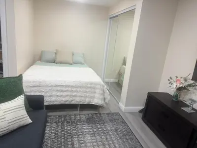 a small bedroom with a bed and a couch at Peaceful Cottage in Vermont Knolls in Los Angeles