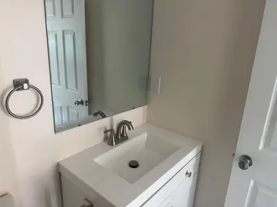 a white bathroom with a sink and a mirror at Peaceful Cottage in Vermont Knolls in Los Angeles