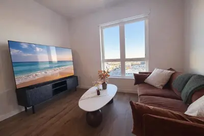 a living room with a couch and a large screen tv at Penthouse Corner 3 Bedroom Condo with Large Private Balcony and Parking in Los Angeles
