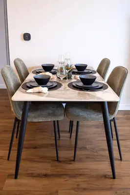 a wooden table with chairs and a table with wine glasses at Penthouse Corner 3 Bedroom Condo with Large Private Balcony and Parking in Los Angeles