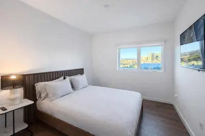 a white bedroom with a bed and a window at Penthouse Corner 3 Bedroom Condo with Large Private Balcony and Parking in Los Angeles