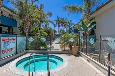 a small swimming pool with a fence and palm trees at Modern West LA Studio with Pool, Gym & Parking in Los Angeles