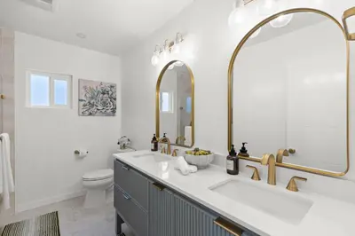 a bathroom with a sink and a toilet and a mirror at NEW Remodeled Northridge 5 Bedroom Near CSUN & Sherwood Forest in Northridge