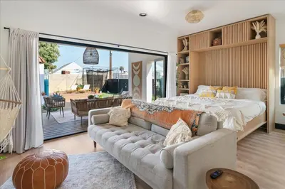 a bedroom with a couch and a bed and a patio at Bohemian Dream Studio Close to LA Stadium SOFI Kia Forum Intuit Dome LA Coliseum in Los Angeles
