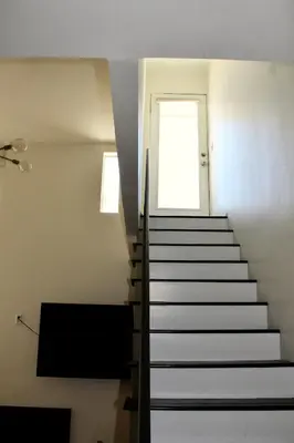 a staircase in a room with a window and a door at Designer Light-Filled WeHo Condo in Los Angeles