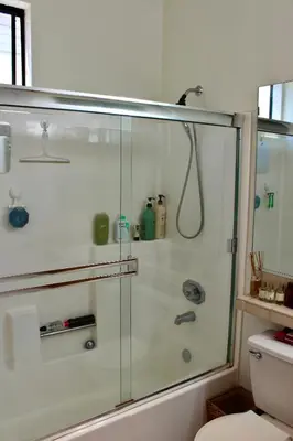 a bathroom with a glass shower with a toilet at Designer Light-Filled WeHo Condo in Los Angeles