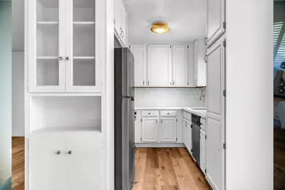 a white kitchen with white cabinets and a refrigerator at Bright and Comfortable 2 Bedrooms with Views in Santa Monica in Los Angeles